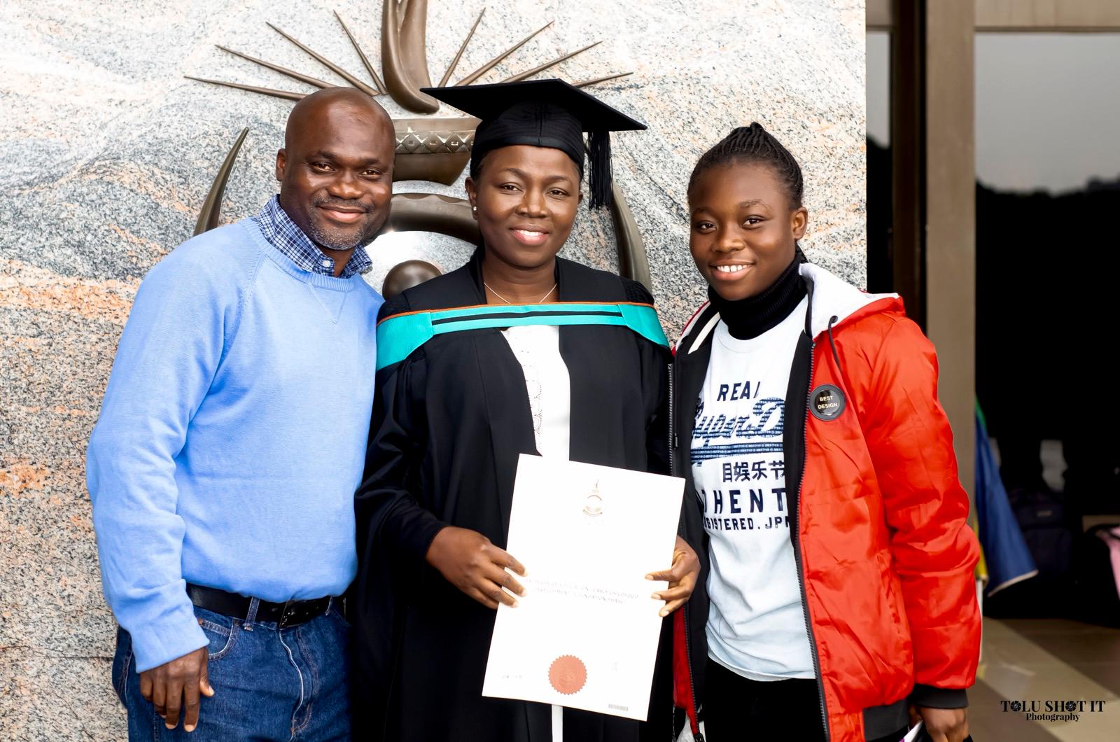 Graduate in sash on campus grounds